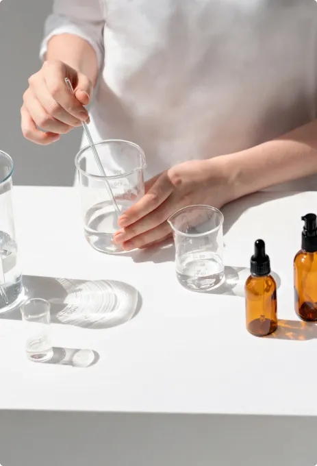 Woman preparing cosmetics formulas in beakers