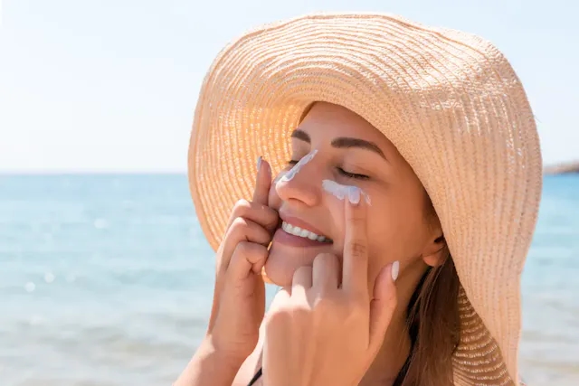 Woman applying sun protection at the beach